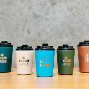 Five Fressko cups with 'Ocean Grind' branding on a wooden surface.