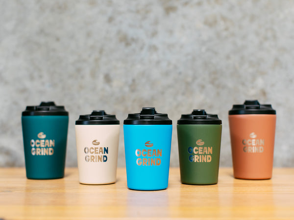 Five Fressko cups with 'Ocean Grind' branding on a wooden surface.
