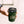 Hand holding a Khaki 'Ocean Grind' coffee cup with a black click lid.